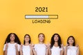 Multiracial Women Pointing At Bar With 2021 Year Loading, Yellow Background