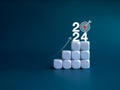 2024 year number with target icon and rise up arrow on white blocks as a graph steps on blue background. Royalty Free Stock Photo