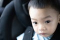 1 Year Old Adorable, an Asian Toddler Boy, Sitting in a Car Seat on a Car While Traveling Looking at the camera