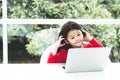 A 6 year old Asian girl wearing a red shirt Watching a cartoons From a notebook with fun and happy Royalty Free Stock Photo