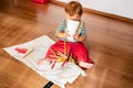 1 year old baby on the floor playing with colored pencils painting Royalty Free Stock Photo