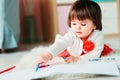 1 year old baby girl drawing with pencils at home Royalty Free Stock Photo