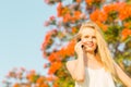 Happy beautiful woman talking on a cellphone in the park.