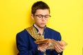 An 11-year-old boy in an adult and oversized suit holds a euro, a portrait of a child with money on a yellow background Royalty Free Stock Photo