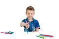 A 6 year old boy in a blue shirt paints with pencils on a white background isolate Royalty Free Stock Photo