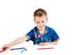 A 6 year old boy in a blue shirt paints with pencils on a white background isolate Royalty Free Stock Photo