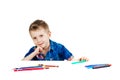 A 6 year old boy in a blue shirt paints with pencils on a white background isolate Royalty Free Stock Photo