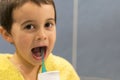 A 5-year-old boy at home washes his teeth with an oral irrigator. Little boy cleaning teeth with oral irrigator. Dental Care