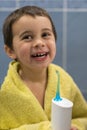 A 3-year-old boy at home washes his teeth with an oral irrigator. Little boy cleaning teeth with oral irrigator. Dental Care