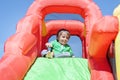 Young boy on inflatable bouncy castle slide at party Royalty Free Stock Photo