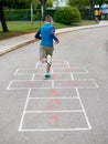 8 year old boy playing hopscotch Royalty Free Stock Photo