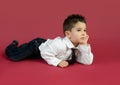 4-year-old boy portrayed with gestures in studio with color background.