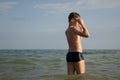 A 10-year-old boy puts on swimming goggles and prepares to swim in the sea. Royalty Free Stock Photo