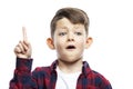 A 7-year-old boy in a red shirt raised his index finger up, has an idea. Isolated on white background Royalty Free Stock Photo