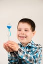 A 4-year-old boy is studying chemistry, holding in his hand a flask with a blue liquid that moves upward from body heat Royalty Free Stock Photo