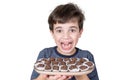 9 year old Brazilian holding a tray with several Brazilian fudge balls and facing the camera with a big smile