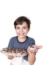9 year old Brazilian holding a tray with several Brazilian fudge balls and in the other hand just a candy