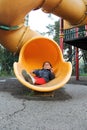 4-year-old brunette Latina girl plays on the slide in the park living in poverty and happy