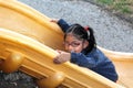 4-year-old brunette Latina girl plays on the slide in the park living in poverty and happy