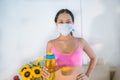 A 20-year-old brunette woman wearing a mask in sportswear rejoicing and drinking water after training Royalty Free Stock Photo