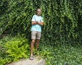 52 year-old Caucasian male posing in front of a dense wall of green ivy in Bar Harbor, Maine.