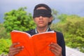 13 year old child with blindfold reading book, on the roof in the rainy season, Indecision and uncertainty conceptual, selective