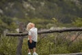 A 4-year-old child climbs a wooden old fence Royalty Free Stock Photo