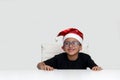 6 year old dark latino boy is ready to celebrate the holidays and write his letter to Santa Claus with Christmas hat