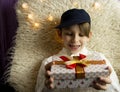 A 10-year-old European boy receives and enjoys a Christmas present