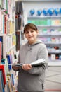 12-year-old girl between bookshelves in store