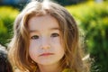 A 3-year-old girl with long, lush blond hair looks into the frame.