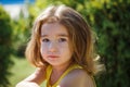 A 3-year-old girl with long, lush blond hair looks into the frame.