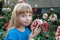 11 year old girl with long white hair with a dahlia flower. Portrait of little toddler girl admiring bouquet of huge Royalty Free Stock Photo