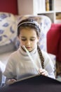 5 year old girl looks at a book with figures Royalty Free Stock Photo