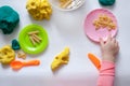 A 1.5 year old girl sits at a table and plays with a color test, on the table are tools and decor elements. View from above, top. Royalty Free Stock Photo