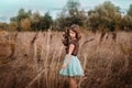 A 10-year-old girl is walking in a field. Dry grass all around. The girl is holding a bouquet. Royalty Free Stock Photo