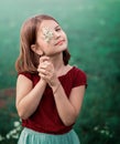 A 10-year-old girl walks in a field with white flowers. The girl is holding a bouquet. Royalty Free Stock Photo