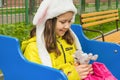 A 9-year-old girl in a yellow jacket pulled toys from her backpack. The child plays in the playground