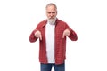60 year old gray-haired pensioner man with a beard and mustache shows his finger to the side Royalty Free Stock Photo