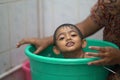 2-year-old Indian baby boy enjoying a bath in a green tub. Royalty Free Stock Photo