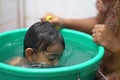 2-year-old Indian baby boy enjoying a bath in a green tub. Royalty Free Stock Photo