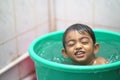 2-year-old Indian baby boy enjoying a bath in a green tub. Royalty Free Stock Photo