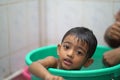 2-year-old Indian baby boy enjoying a bath in a green tub. Royalty Free Stock Photo