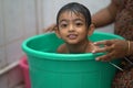 2-year-old Indian baby boy enjoying a bath in a green tub. Royalty Free Stock Photo