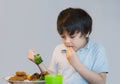 7 year old kid boy having homemade chicken nuggets and roat potato and broccoli for Sunday dinner at home, Happy child eating Royalty Free Stock Photo