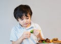 7 year old kid boy having homemade chicken nuggets and roat potato and broccoli for Sunday dinner at home, Happy child eating Royalty Free Stock Photo