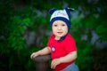 A 2-year-old kid in a bright red T-shirt on a background of green grass. Royalty Free Stock Photo