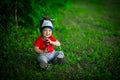 A 2-year-old kid in a bright red T-shirt on a background of green grass. Royalty Free Stock Photo