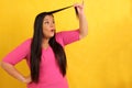 40-year-old Latina woman with long hair suffers from having it mistreated, observes her damaged split ends that need treatment Royalty Free Stock Photo