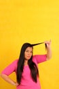 40-year-old Latina woman with long hair suffers from having it mistreated, observes her damaged split ends that need treatment Royalty Free Stock Photo